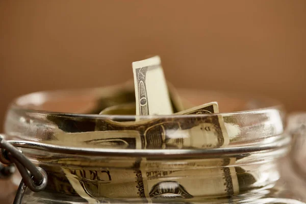 Close up view of glass jar with dollar banknotes — Stock Photo