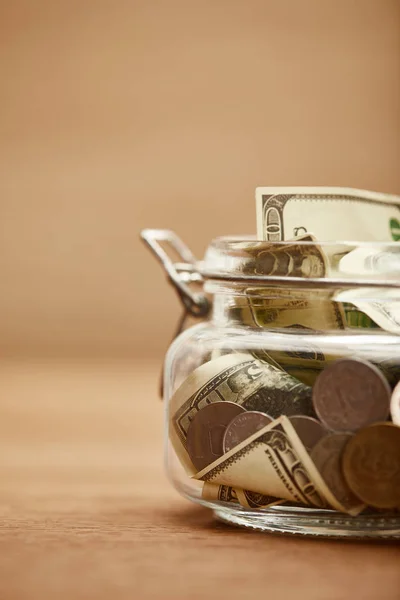 Close up view of glass jar with dollar banknotes and coins — Stock Photo