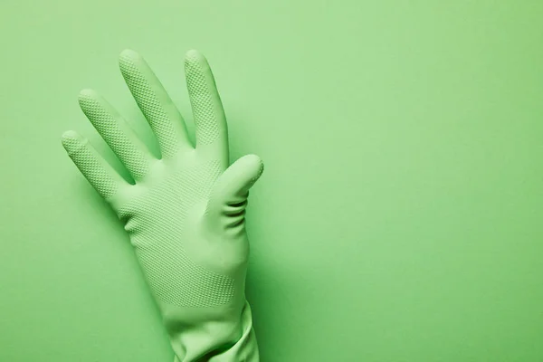 Cropped view of man in rubber glove on green background — Stock Photo
