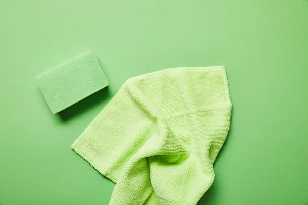 Top view of colorful rag and sponge on green background — Stock Photo