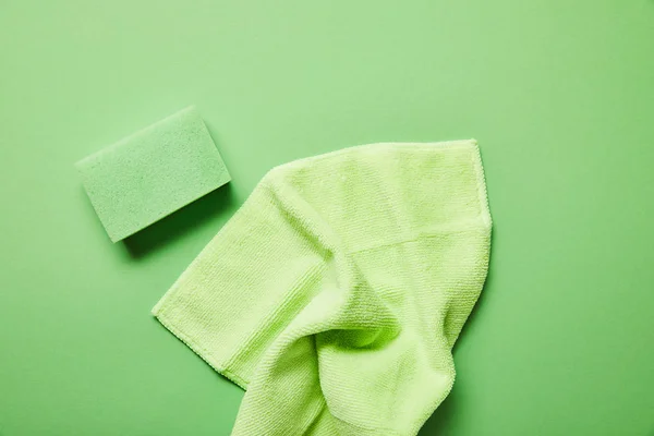 Vista superior de trapo colorido y esponja sobre fondo verde — Stock Photo