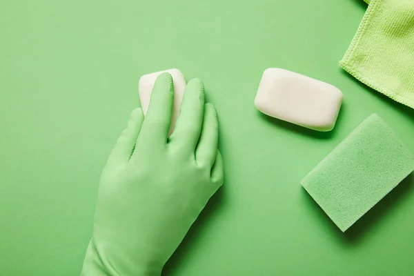 Cropped view of man in rubber glove holding white soap — Stock Photo