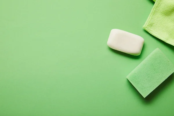 Vista dall'alto di sapone bianco, straccio e spugna su sfondo verde — Foto stock