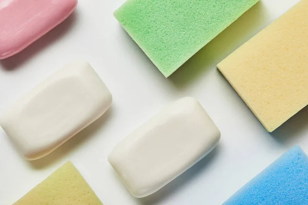 Top view of white and pink soaps, colorful and bright sponges — Stock Photo