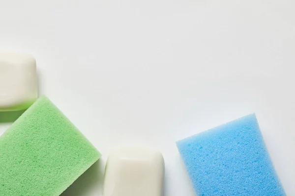 Top view of white soaps, green and blue sponges — Stock Photo