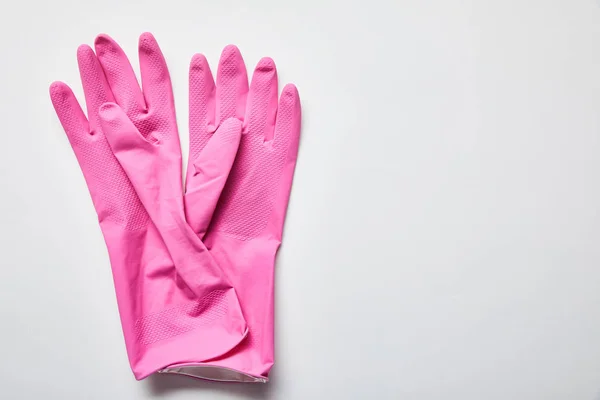 Vista superior de luvas de borracha rosa no fundo cinza com espaço de cópia — Fotografia de Stock