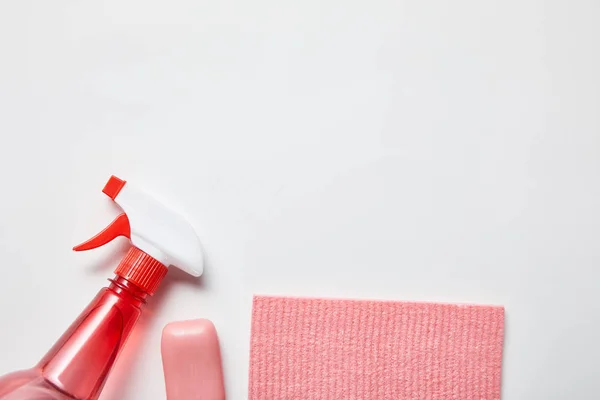Draufsicht auf rosa Lappen und Seife, Flasche mit Spray auf grauem Hintergrund — Stockfoto