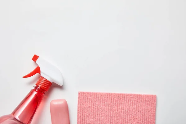 Vista dall'alto di straccio rosa e sapone, bottiglia con spray su fondo grigio — Foto stock