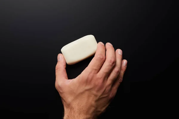 Cropped view of man holding white soap isolated on black — Stock Photo