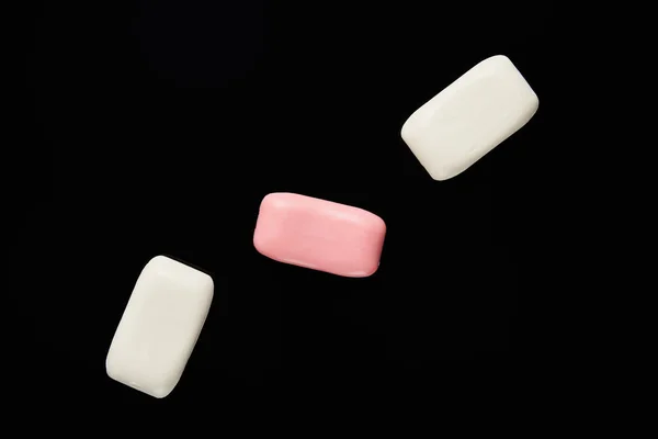 Top view of pink and white soaps isolated on black — Stock Photo