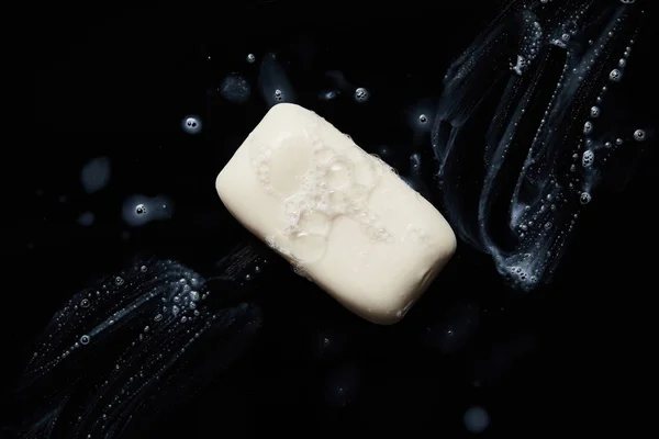 Top view of white soap with drops on black background — Stock Photo