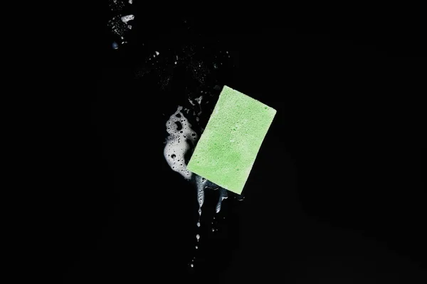 Vista superior de la esponja verde y colorida sobre fondo negro - foto de stock