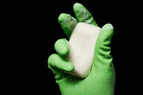 Cropped view of man in green rubber glove holding soap isolated on black — Stock Photo