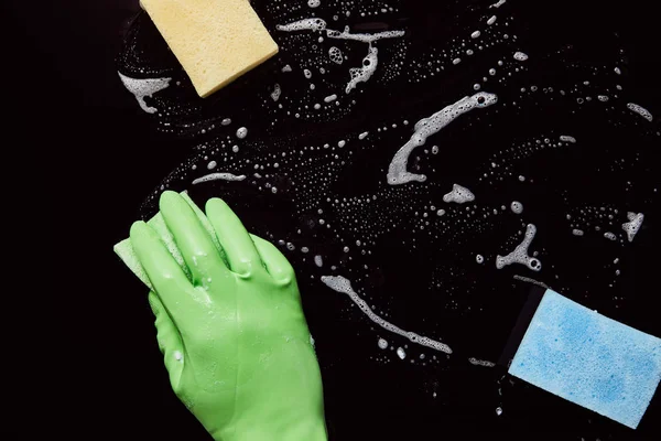 Cropped view of man in rubber glove cleaning with green sponge — Stock Photo