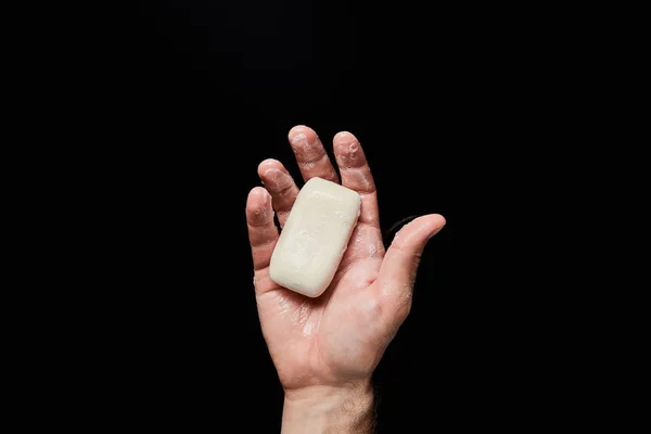 Vista dall'alto di uomo in possesso di sapone bianco isolato su nero — Foto stock