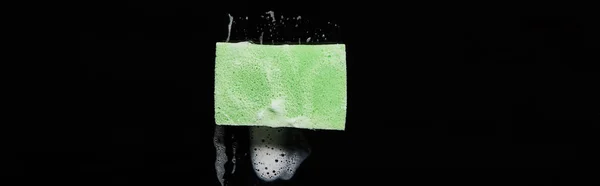 Tiro panorâmico de esponja verde e colorida com espuma no fundo preto — Fotografia de Stock