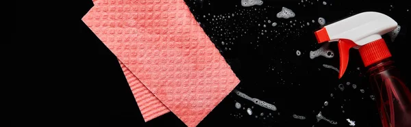 Top view of pink rag and bottle with spray on black background — Stock Photo