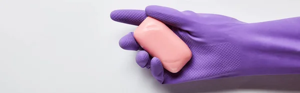 Plan panoramique de l'homme en gant de caoutchouc violet tenant du savon rose — Photo de stock