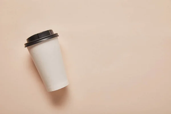 Vue du dessus de la tasse en papier avec espace de copie sur fond beige — Photo de stock