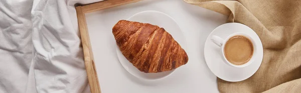 Top view of fresh croissant with coffee on wooden tray in bed at morning, panoramic shot — Stock Photo