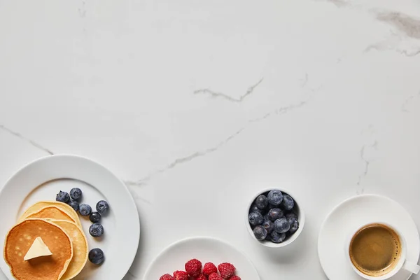 Blick von oben auf leckere Pfannkuchen mit Beeren und Tasse Kaffee — Stockfoto