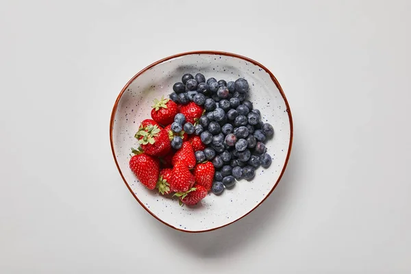 Vue de dessus de la grande assiette avec de délicieux bleuets et fraises — Photo de stock