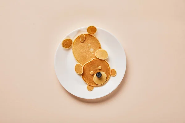 Top view of pancakes on plate with one blueberry on pink, bear concept — Stock Photo