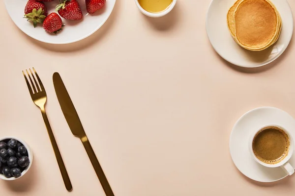 Вид зверху подається сніданок з ягодами, кавою, млинцями і порожнім місцем посередині — стокове фото