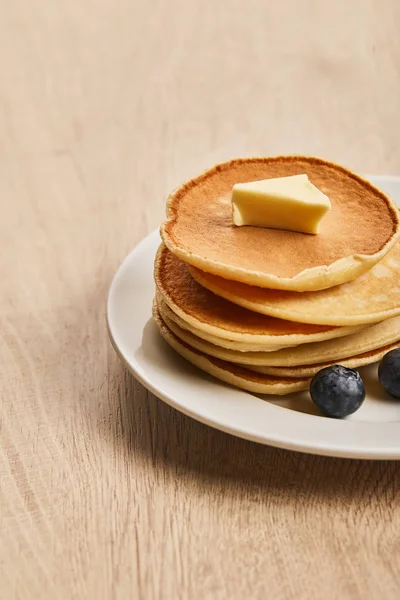 Crêpes au beurre et aux bleuets sur assiette en bois — Photo de stock