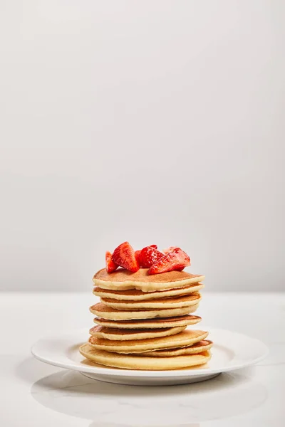 Panquecas para o café da manhã com morangos em placa branca isolada em cinza — Fotografia de Stock