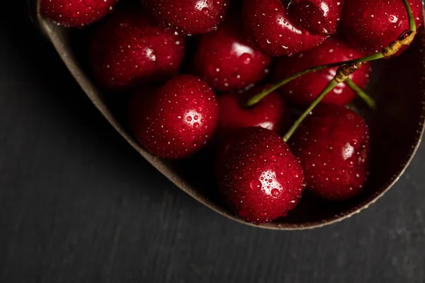 Top view of wet delicious cherries in metal basket on wooden dark table — Stock Photo