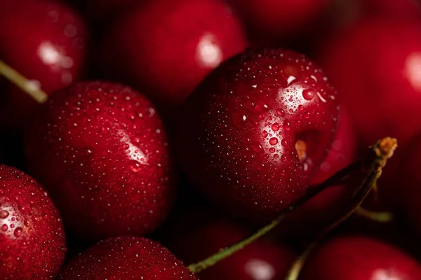 Vista de perto de cerejas vermelhas saborosas e frescas com gotas de água — Fotografia de Stock