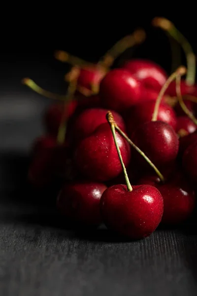 Selective focus of red delicious and ripe cherries on wooden surface — Stock Photo