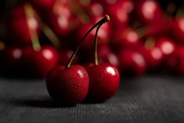 Selective focus of red delicious sweet cherries on wooden table — Stock Photo