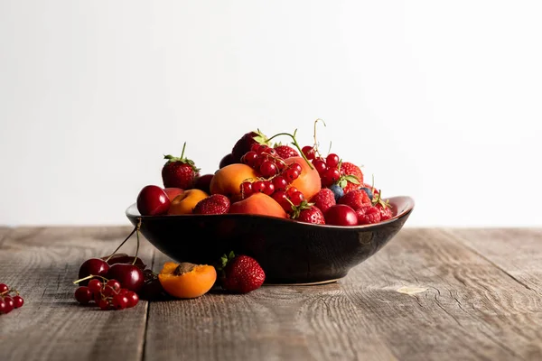 Assiette avec de délicieuses baies mûres mélangées sur table en bois isolé sur blanc — Photo de stock