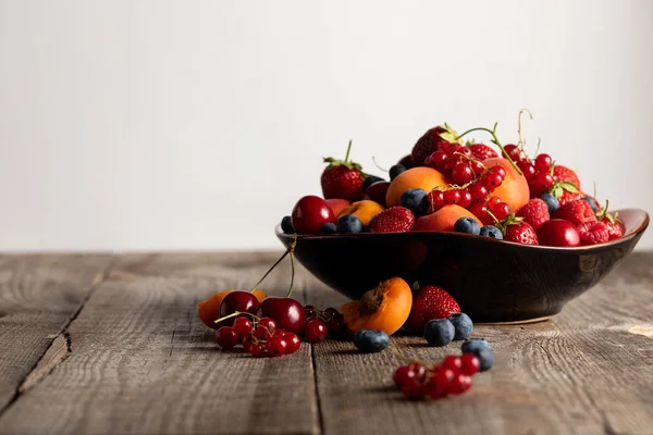 Plate with fresh mixed delicious berries on wooden table isolated on white — Stock Photo