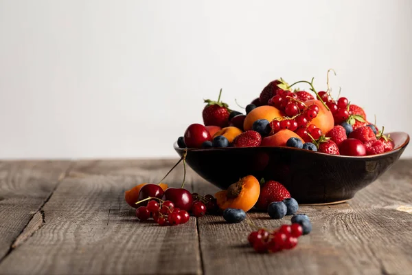 Assiette avec des baies fraîches mélangées délicieuses sur table en bois isolé sur blanc — Photo de stock