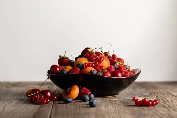 Teller mit gemischten köstlichen Beeren auf Holztisch isoliert auf weiß — Stockfoto