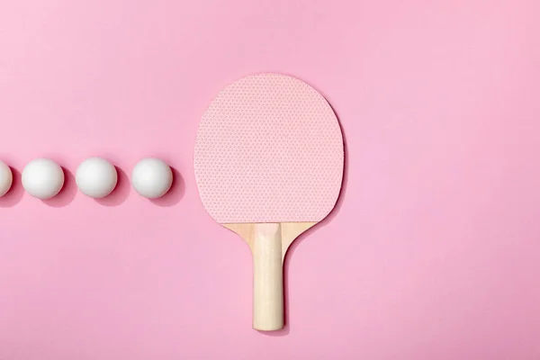 Flat lay com bolas de tênis de mesa e raquete em fundo rosa — Fotografia de Stock