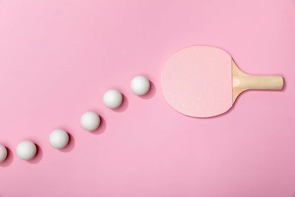Vista superior de pelotas de tenis de mesa y raqueta rosa sobre fondo rosa - foto de stock