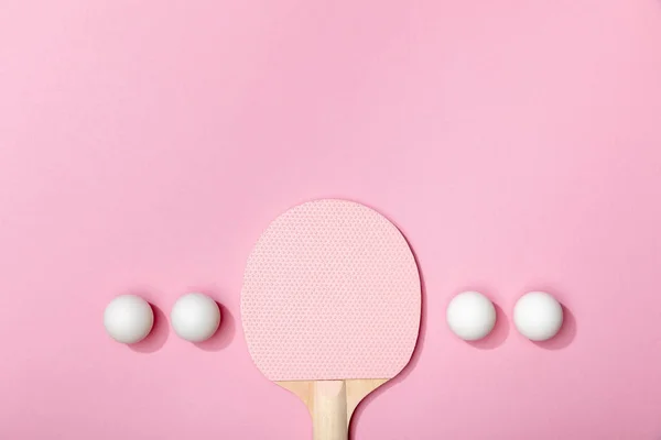 Flat lay com bolas de tênis de mesa branco e raquete de madeira no fundo rosa — Fotografia de Stock