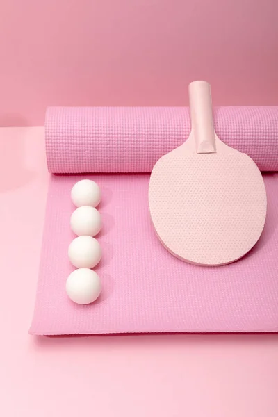 Flat lay com bolas brancas de ping-pong e raquete no tapete de fitness no fundo rosa — Fotografia de Stock