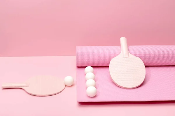 Bolas de pingue-pongue branco e raquetes rosa no tapete de fitness no fundo rosa — Fotografia de Stock