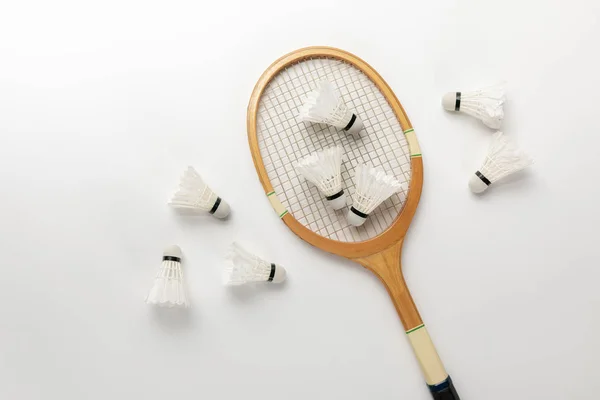 Top view of wooden badminton racket and shuttlecocks on white background — Stock Photo