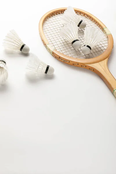 Close up view of wooden badminton racket and shuttlecocks on white background with copy space — Stock Photo
