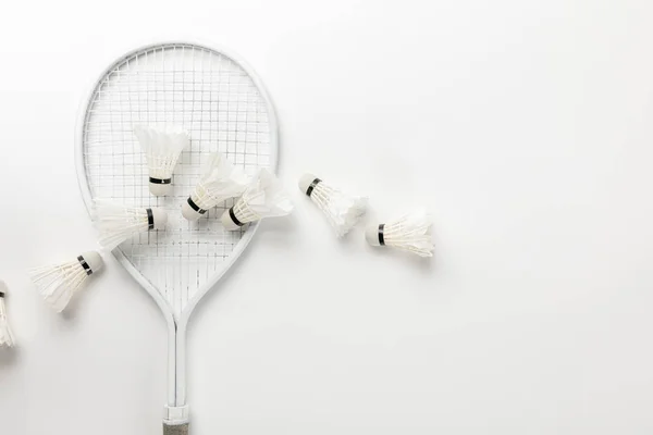 Vue de dessus de raquette de badminton blanc et des navettes sur fond blanc — Photo de stock