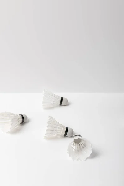 Branco badminton shuttlecocks espalhados no fundo branco com espaço de cópia — Fotografia de Stock