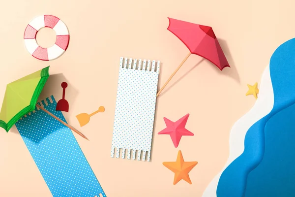 Vue de dessus de la plage de papier avec serviettes, parasols, bouée de sauvetage et mer — Photo de stock