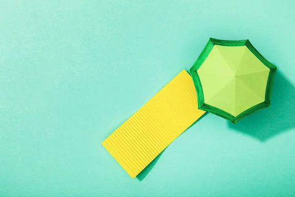 Top view of paper towel and umbrella on turquoise background — Stock Photo