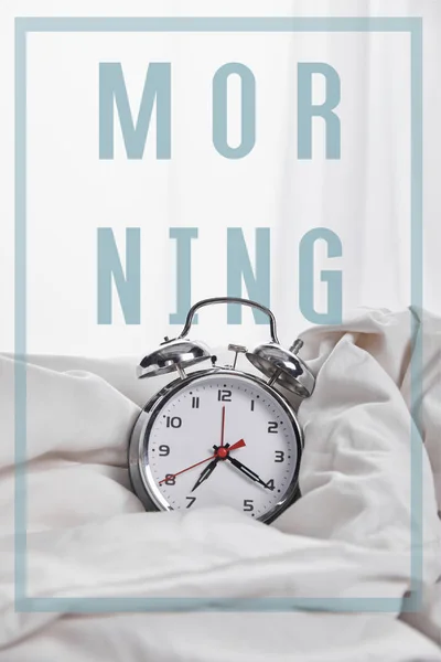 Silver alarm clock in blanket in white bed with morning illustration — Stock Photo